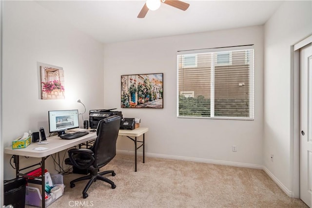 carpeted office space with baseboards and a ceiling fan