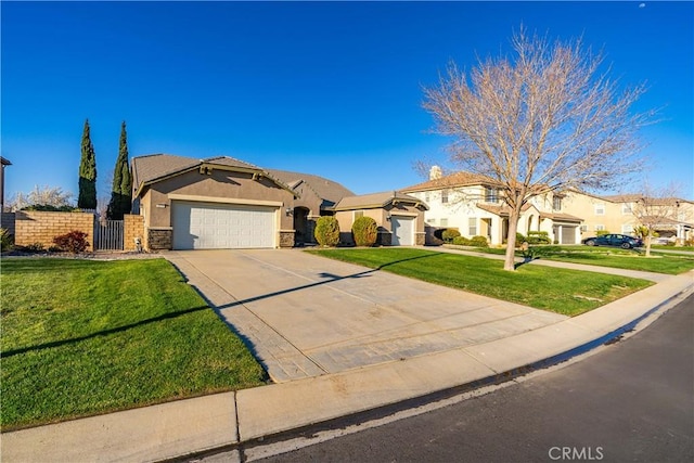 mediterranean / spanish house with fence, a residential view, a front yard, driveway, and an attached garage