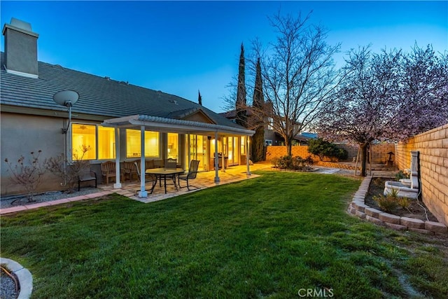 rear view of house featuring a yard, a fenced backyard, a pergola, a chimney, and a patio area