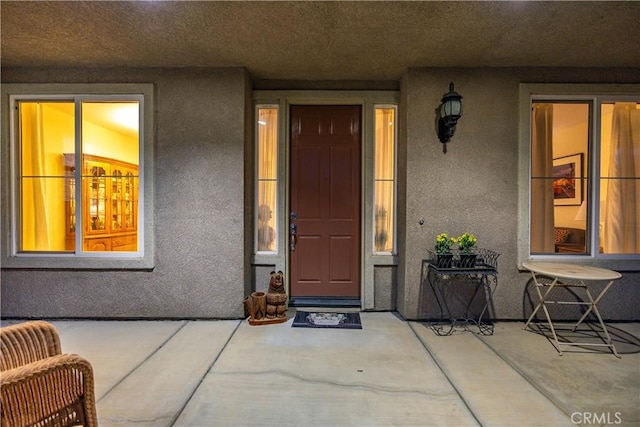 view of exterior entry featuring stucco siding