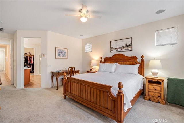 bedroom with light tile patterned floors, light colored carpet, visible vents, and ceiling fan