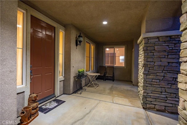 property entrance with stucco siding and stone siding