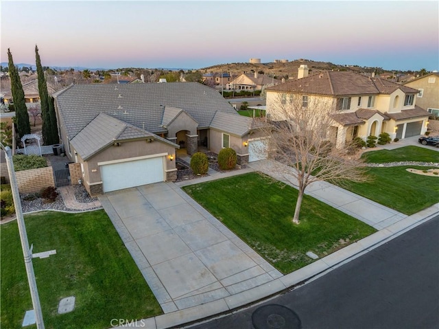 view of front facade with stucco siding, a front lawn, a residential view, concrete driveway, and a garage