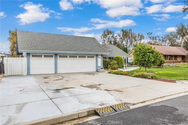 view of front facade featuring a shingled roof, a front lawn, fence, a garage, and driveway