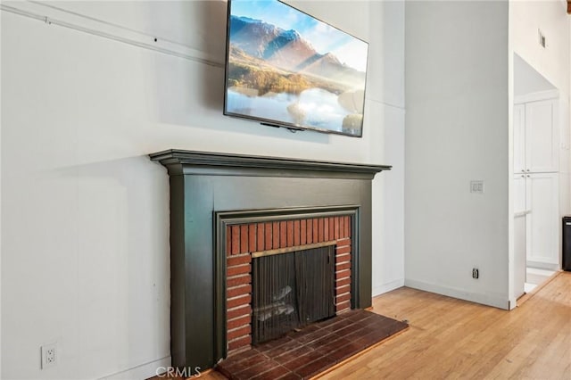 details with a fireplace, wood finished floors, and baseboards