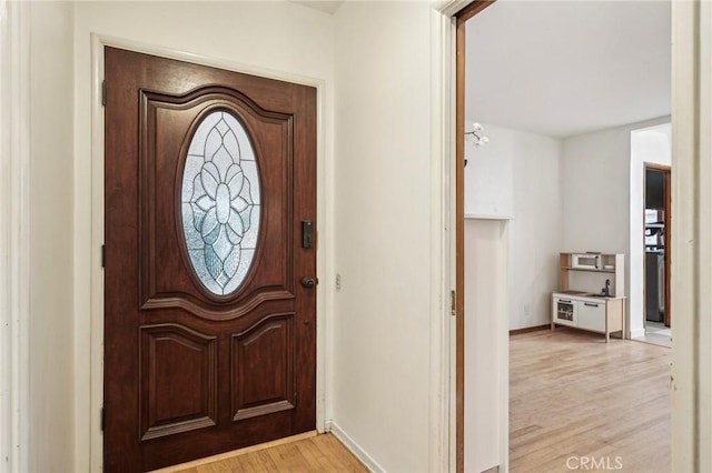 entryway with light wood-style flooring and baseboards