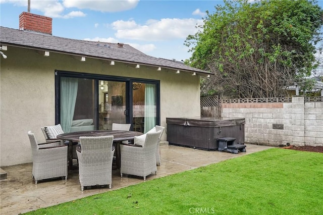 back of property featuring a patio, a lawn, a hot tub, stucco siding, and fence