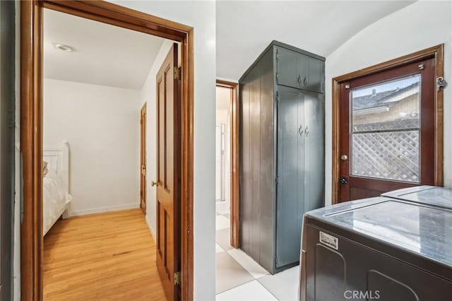 bathroom with wood finished floors, washing machine and clothes dryer, vaulted ceiling, and baseboards
