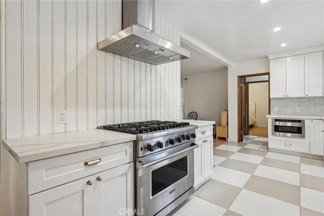 kitchen featuring stainless steel appliances, recessed lighting, ventilation hood, light floors, and backsplash