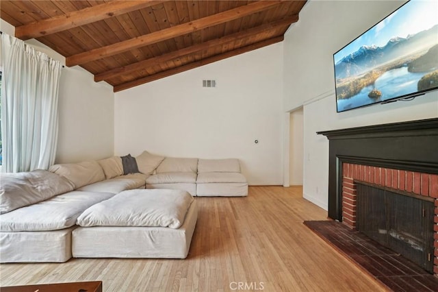 living area with visible vents, wooden ceiling, a fireplace, and lofted ceiling with beams