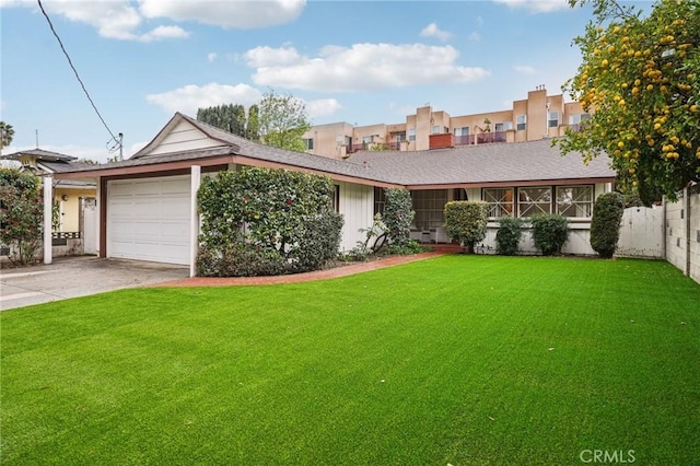 view of front of property with a front lawn, an attached garage, fence, and concrete driveway