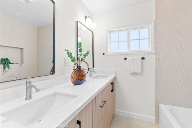 bathroom with double vanity, baseboards, tile patterned floors, and a sink