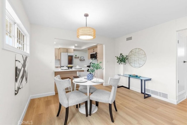 dining room with visible vents, baseboards, and light wood-style floors