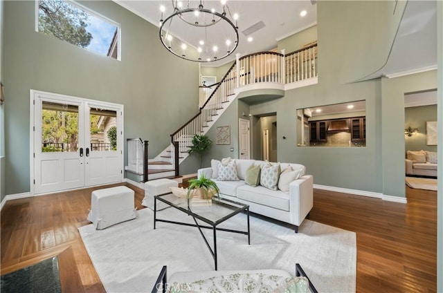 living room with stairway, plenty of natural light, wood finished floors, and baseboards