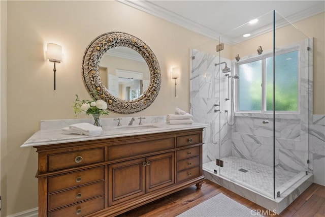 full bath featuring a marble finish shower, wood finished floors, and crown molding