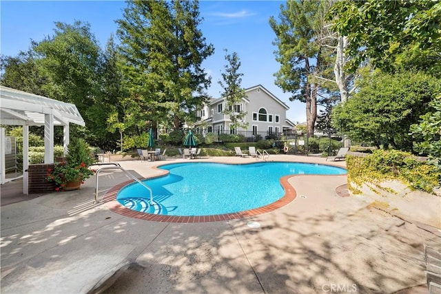 community pool featuring fence and a patio area