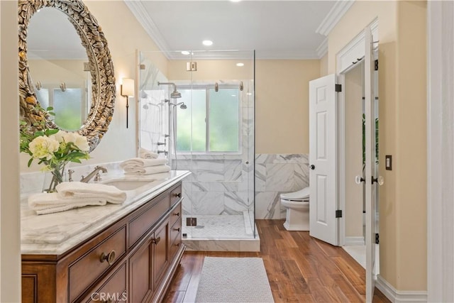 full bathroom with toilet, a stall shower, ornamental molding, wood finished floors, and vanity