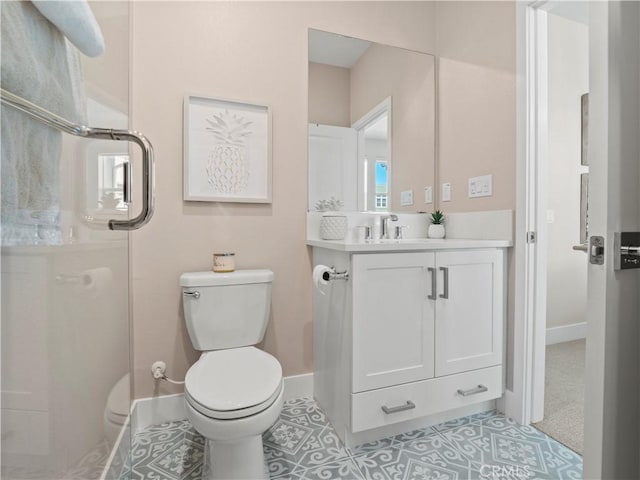 bathroom with vanity, tile patterned floors, toilet, and baseboards