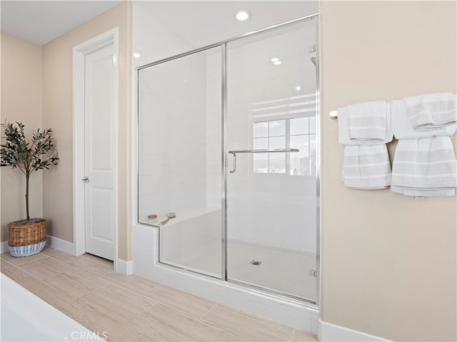 full bathroom featuring a stall shower and baseboards