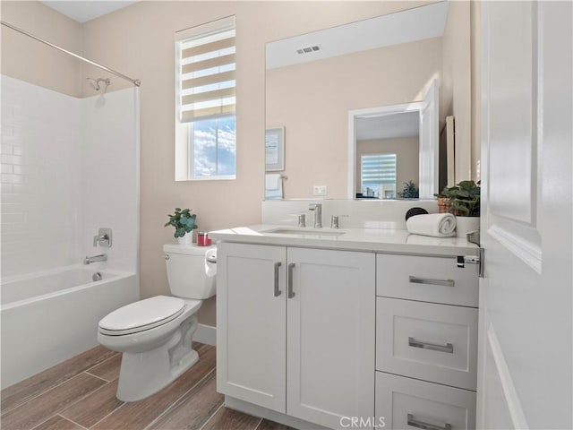 full bath featuring visible vents, wood tiled floor, shower / washtub combination, toilet, and vanity