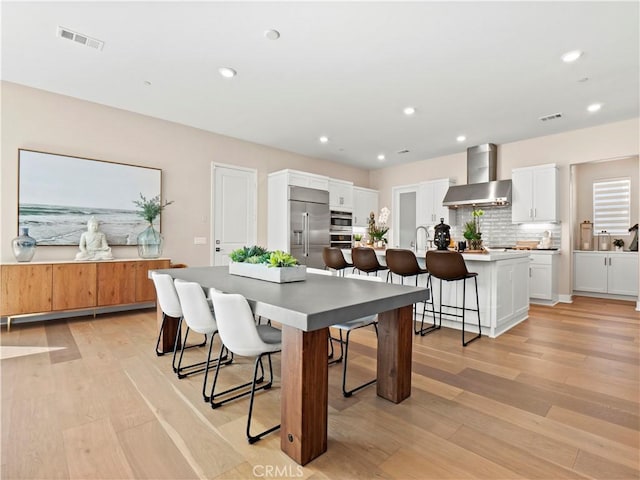 dining area featuring recessed lighting, light wood-type flooring, and visible vents