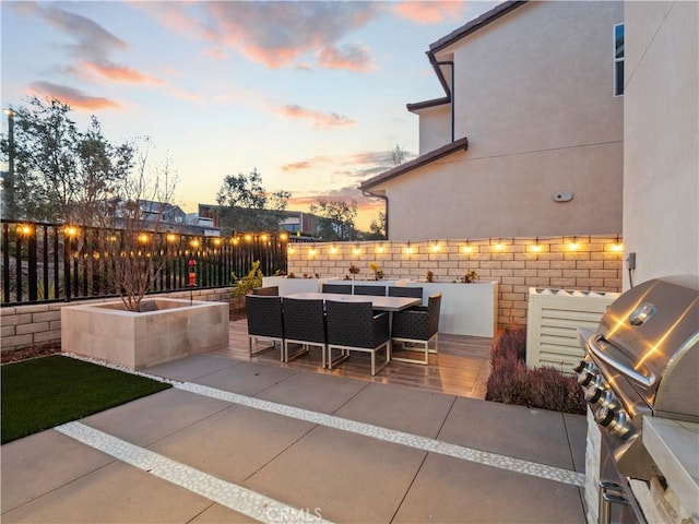 view of patio with outdoor dining area, a grill, and fence