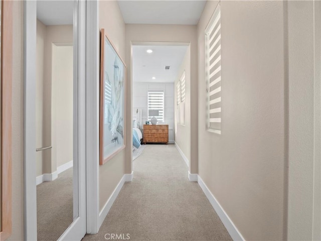 corridor featuring recessed lighting, carpet flooring, visible vents, and baseboards