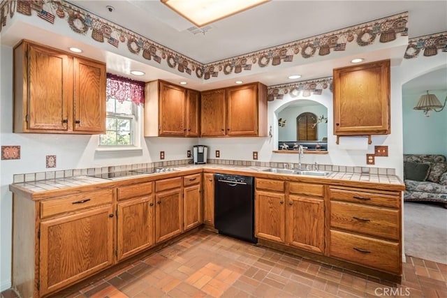 kitchen featuring tile countertops, brick floor, a sink, black appliances, and brown cabinets