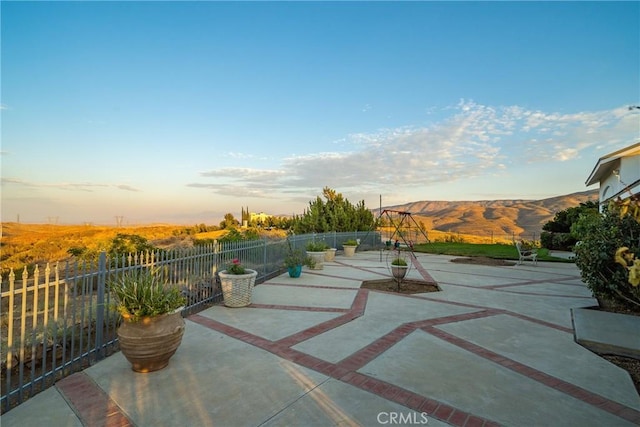 view of patio featuring a mountain view and fence