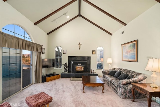 living area with beam ceiling, carpet, visible vents, and high vaulted ceiling