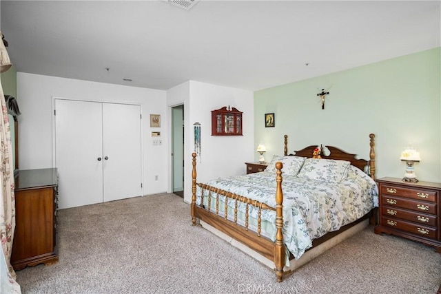 carpeted bedroom featuring a closet and visible vents