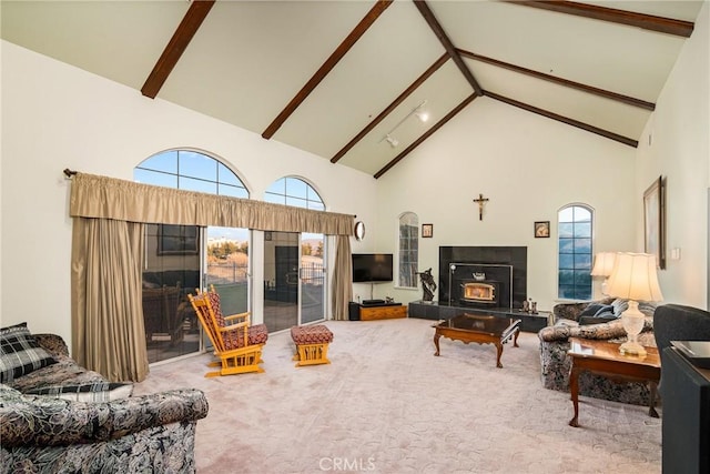 carpeted living area with beam ceiling, high vaulted ceiling, and a tile fireplace