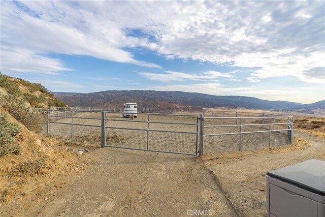 view of yard with a mountain view, a rural view, and a gate