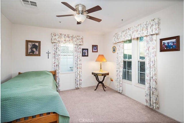 bedroom featuring a ceiling fan, multiple windows, carpet, and visible vents