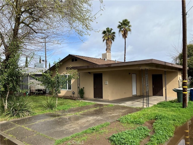 single story home with a front yard and stucco siding