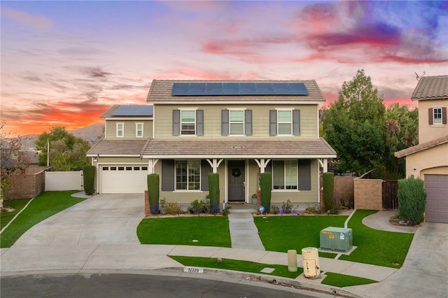 traditional-style home with solar panels, fence, a porch, a front yard, and driveway