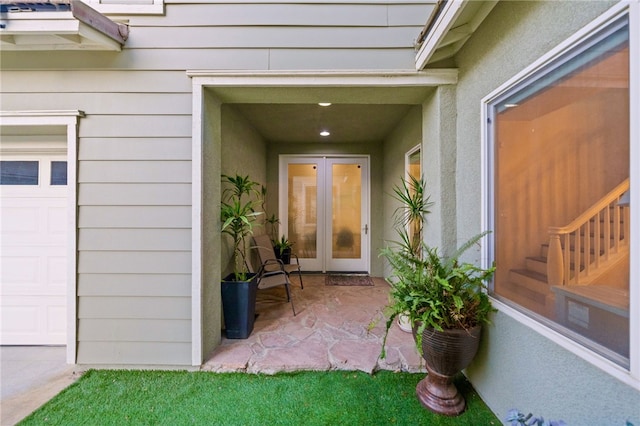 property entrance featuring stucco siding and a garage