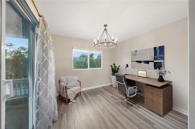 office area with baseboards, light wood-style floors, and an inviting chandelier