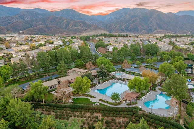 aerial view at dusk featuring a residential view and a mountain view