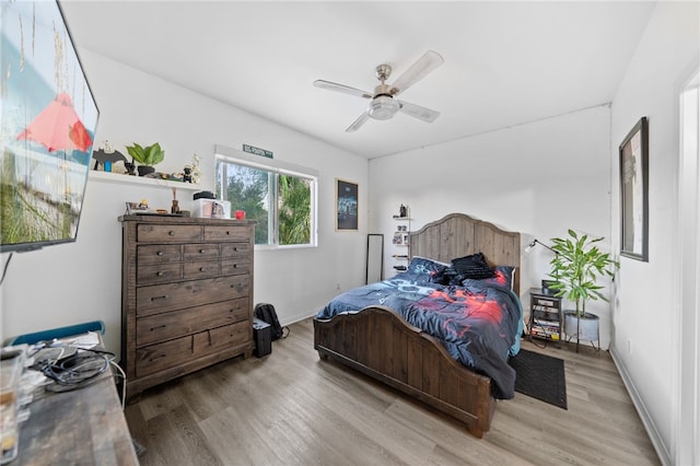 bedroom with baseboards, ceiling fan, and wood finished floors