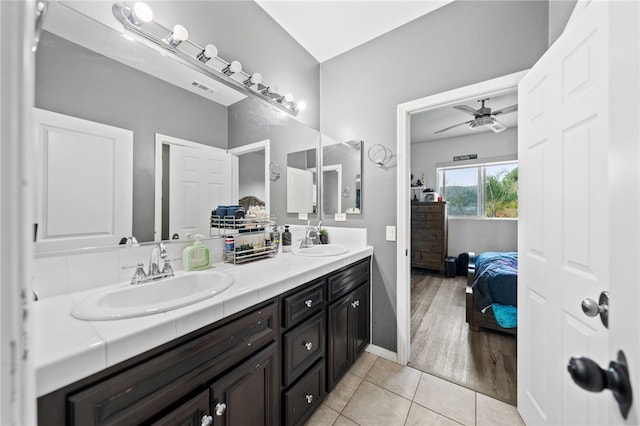 bathroom featuring double vanity, connected bathroom, a ceiling fan, and a sink