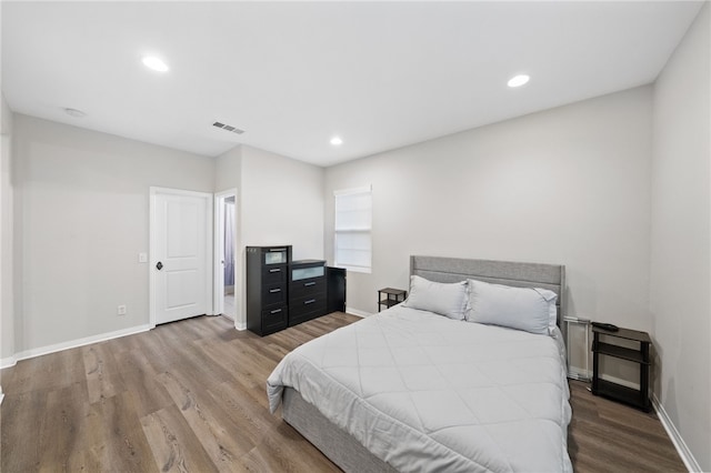 bedroom featuring visible vents, baseboards, and wood finished floors