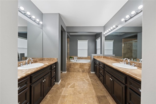 bathroom with a sink, a garden tub, two vanities, and a tile shower