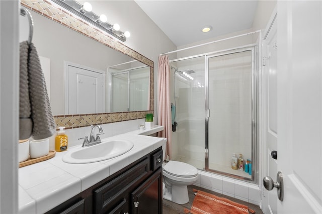 bathroom featuring vanity, toilet, and a stall shower