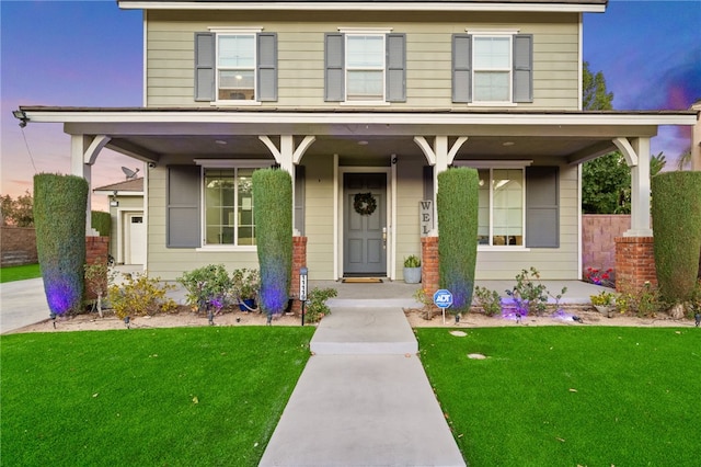 view of front of property featuring a front yard and covered porch