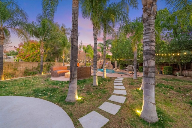 view of home's community with a pool, a patio area, a lawn, and a fenced backyard