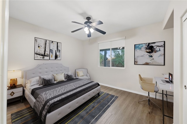 bedroom featuring ceiling fan, baseboards, and wood finished floors