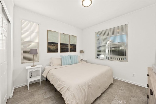 bedroom featuring a closet, multiple windows, and crown molding