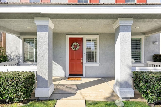 entrance to property with stucco siding and a porch