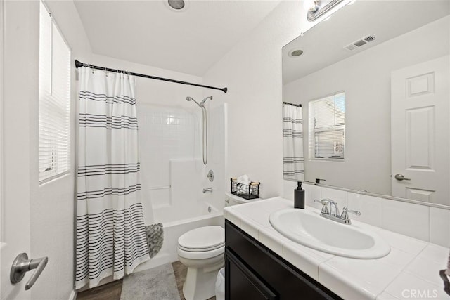 full bathroom featuring visible vents, toilet, shower / tub combo with curtain, and vanity